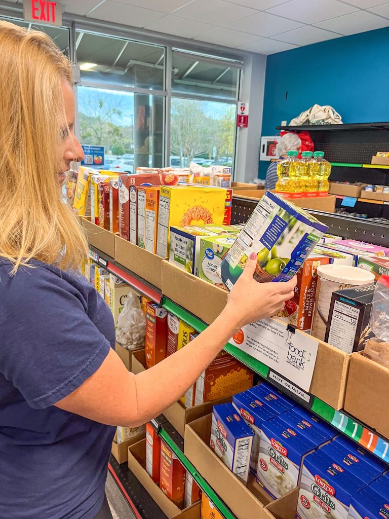 A woman examining a box of instant oatmeal at the NeighborUp pantry.